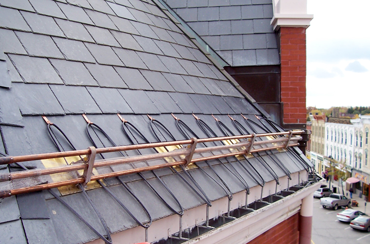 slate tiles with snow rails on historical sloped roof