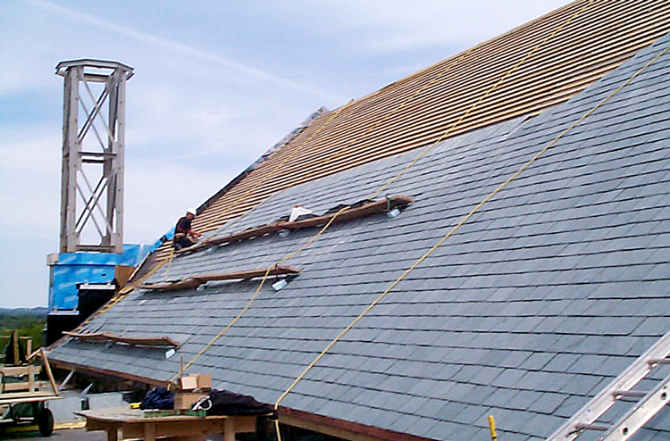 provincial roofing employees shingling steep sloped roof